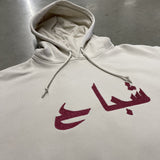 sweat à capuche blanc cassé et broderie rouge écriture arabe 